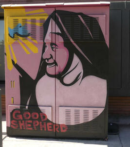 Utility box with painting of a nun, and words “Good Shepherd”