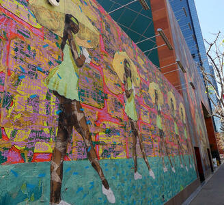 Painting on exterior of MOCA of black women in green miniskirts