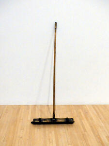 Bronze long-handled, wide-brush broom.