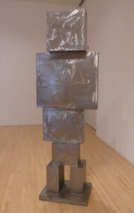 Humanoid figure made of stacked shiny metal blocks.