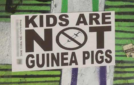 Text: “Kids are not guinea pigs” with needle and slash through O of “NOT”