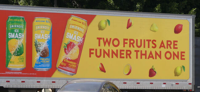 Advert on side of truck for Smirnoff two-fruit drinks: Two fruits are funner than one