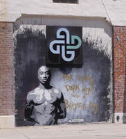 Wall art of Tupac Shakur with text: For every dark night there’s a brigher day