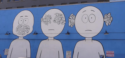 Wall art: speak/see/hear no evil with three faces whose mouth, eyes, and ears are covered with dollar bills