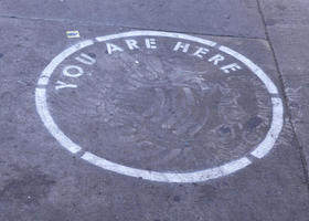 Spary-painted circle with stenciled text: YOU ARE HERE