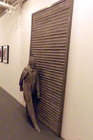 Front view of vertical grooved person walking in front of horizontal grooved wall