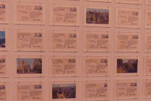 Wall of postcards, most on back side with a few on front