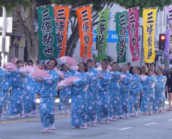 Women in blue kimonos holding pink fans