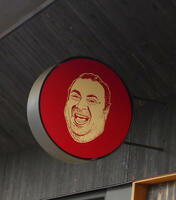 Drawing of chubby smiling man’s face; logo for Vito’s Pizza