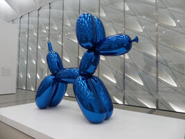 Large stainless steel sculpture with blue transparent coating in shape of a balloon dog