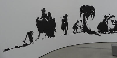 More silhouettes of people dancing; one setting fire to a tree