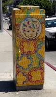 Utility box with painting of child's face on abstract geometric background