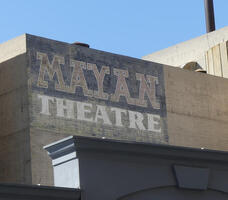 Wall of building with words Mayan Theatre painted on it
