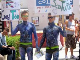 Two men in blue body paint with sea turtle motif