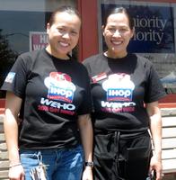 IHOP waitresses wearing special shirts showing a stack of pancakes in rainbow colors