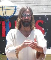 Bearded man dressed as Jesus, wearing sunglasses