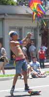 Shirtless skateboarder holding rainbow pinwheel
