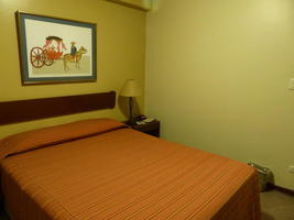 Bedroom with orange-ish bedspread.