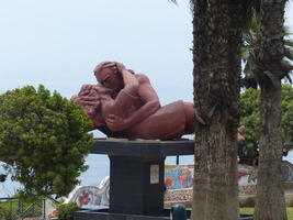 Large sculpture of two people embracing and kissing.