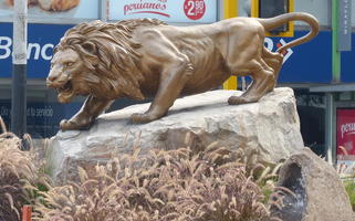 Bronze sculpture of lion about to pounce