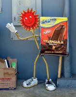 stick figure with red sun as head, holding advert for ice cream