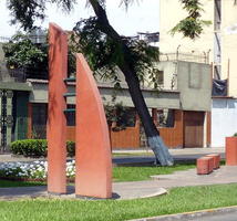 Rust-colored abstract sculpture in median