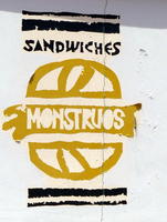 Sign for “Monstrous Sandwiches” shop; word “Monstrous” inside a sandwich