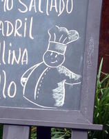 Cartoonish chef drawn in chalk on restaurant menu blackboard