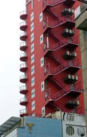 Tall red building with rounded balconies and outside staircase
