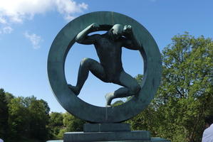 Man inside circular stone, pushing outwards