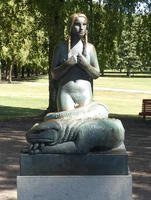 Kneeling woman with large iguana/snake around her knees