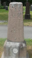 Obelisk-shaped headstone with carving at bottom