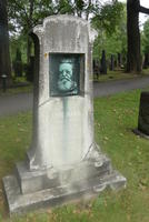 Headstone with bronze of bearded man inset in center