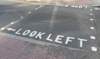 Embossed painting on road “Look Left” and “Look Right” with arrrows