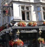 Pub with red flowers in pots on awning