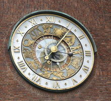 Clock with roman numerals and zodiac symbols