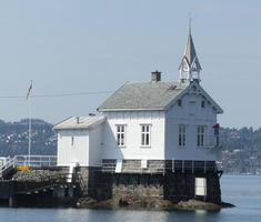White lighthouse resembling an ordinary house with a church steeple
