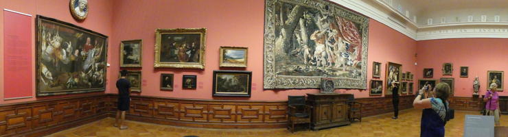Panoramic view of gallery with paintings and large tapestry