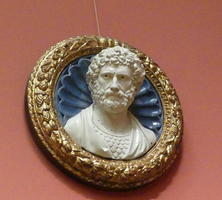 Bust of bearded man within gold circular frame with blue shell background
