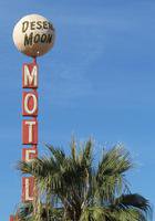 Sign at Desert Moon Motel; words “Desert Moon” are on a gray sphere