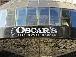 Exterior of Oscar's Steakhouse; sign reads “Oscar's / Beef Booze Broads”