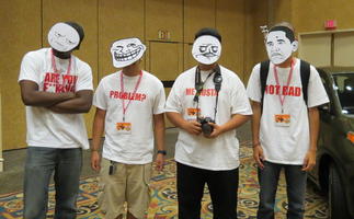 Four people wearing paper face masks using internet “meme” expressions, with corresponding text on t-shirts.