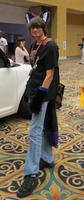 Man wearing purple fur ears, gloves, and tail.