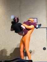 Man in bright orange bodysuit lifting lady.