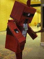 Person dressed as robot (costume made of red-painted cardboard boxes)