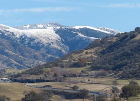Hill in foreground, snow-capped mountain in background