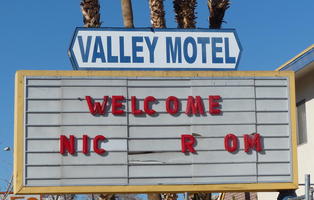 Abandoned motel sign reading “Welcome NIC R OM”