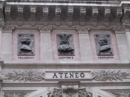 Relief busts of Velasquez, Alfonso X, and Cervantes on a building named Ateneo