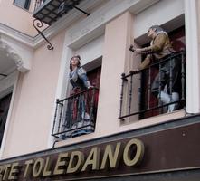 Lifelike figures in traditional Spanish garb on balcony
