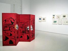 Red shoji screen in foreground; small paintings in background